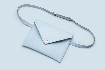 Women's light blue leather waist bag on light blue background