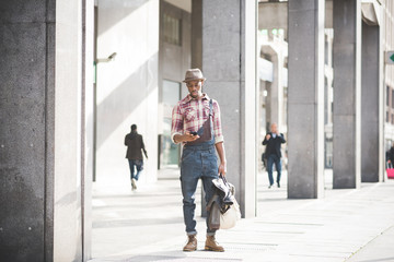 young handsome black man millennial walking outdoor using smart phone - technolofy, social network, remote working concept