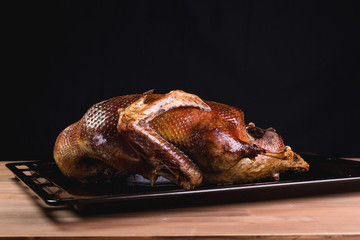 Beautiful food: baked whole duck close-up on a platter on the table.
