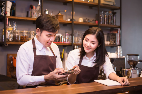 Asian couple barista  working in coffee shop counter.  Barista working at cafe. People working with small business owner or sme concept.