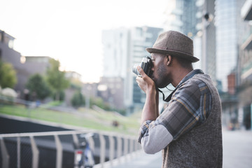 young handsome black millennial man outdoor using camera taking photos - influencer, photographer,...