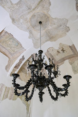 ancient black glass chandelier hanging on a frescoed ceiling