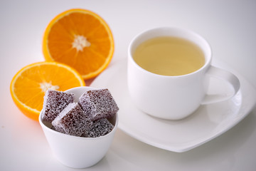 orange marmalade candy with a cup of tea on white table