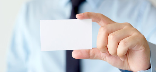 Businessman hand holding blank white business card with copy space for text, business mock up background concept