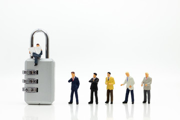 Miniature people:  Businessman sitting on master key encoding. Image use for background security...