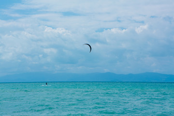 Silhouette of a kite surfer on horizon