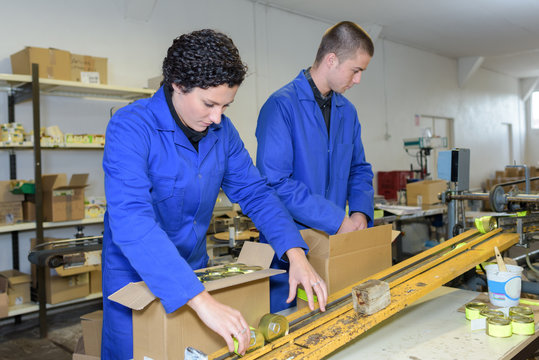 young workers packing products off of factory production line