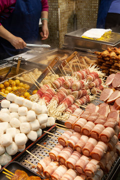 Mid section of a man preparing food at a night market stall