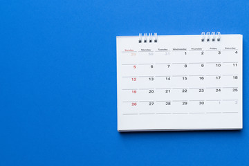 close up of calendar on blue background planning for business meeting or travel planning concept