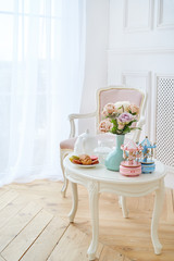 White wooden round table with breakfast, flowers and merry-go-round musical carousel with horses...