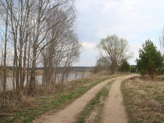 Fototapeta na wymiar country road along the river in the spring