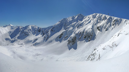 Obraz premium Panorama of Low Tatras with Mount Chopok peak on a sunny winter day.