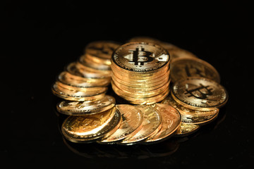 The golden Bitcoin stacked on black background, Conceptual image for worldwide crypto currency, huge stack physical version of golden Bitcoin.