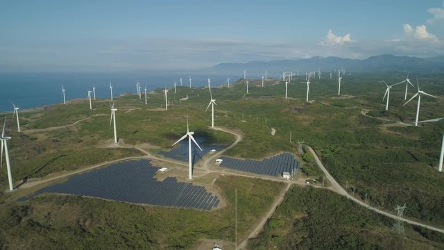 Aerial view of Windmills for electric power production on the seashore. Bangui Windmills in Ilocos Norte, Philippines. Solar farm, Solar power station. Ecological landscape: Windmills, sea, mountains