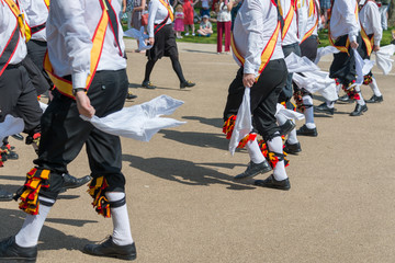 Morris Men wearing bells and white shirts and stockings dance on May Day Bank Holiday with sticks...