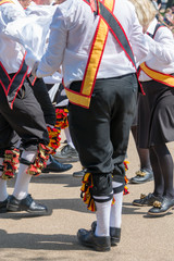 Morris Men wearing bells and white shirts and stockings dance on May Day Bank Holiday with sticks...