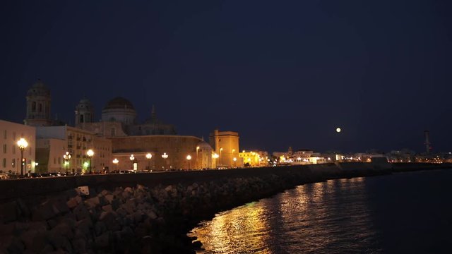 Night view of Cathedral and ocean coast in Cadiz. Andalusia, Spain