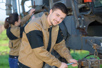 agricultural mechanics checking tractors condition before harvesting