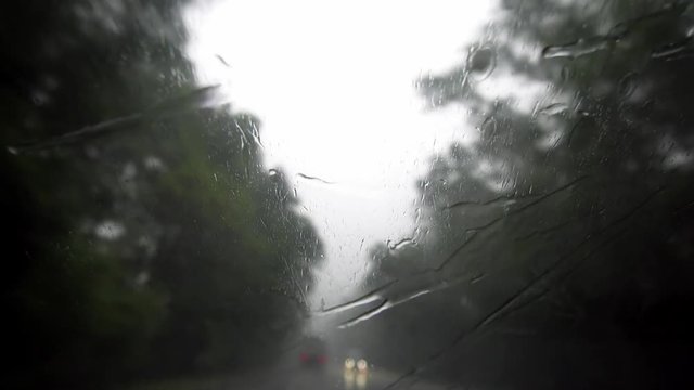 Heavy Rain Behind Windscreen with Moving Wipers. Danger on Road. Near-Zero Visibility