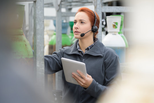 pretty warehouse manager using tablet pc in a large warehouse