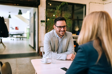 Fototapeta premium Young businessman looking at the woman on a date in cafe.