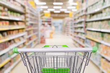 Empty shopping cart with abstract blur supermarket discount store aisle and product shelves interior defocused background © Kwangmoozaa