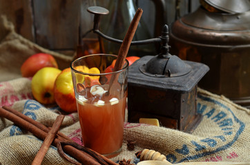 Hot drink with apples and cinnamon in a glass