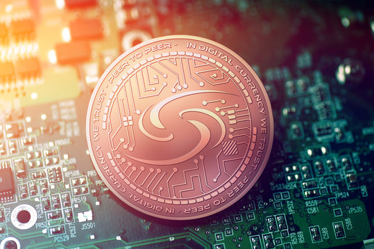 shiny copper SYSCOIN cryptocurrency coin on blurry motherboard background