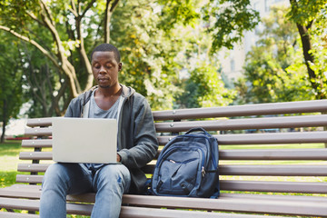 Concentrated man working on his laptop outdoors