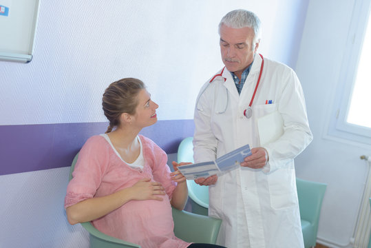 pregnant woman consulting male doctor