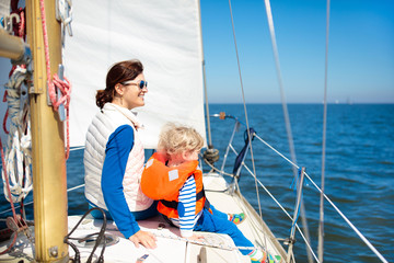 Family sailing. Mother and child on sea sail yacht.