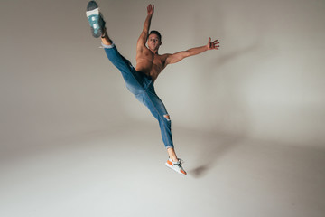Naklejka premium shot of mad, crazy, cheerful, successful, lucky guy in casual outfit, jeans, jumping with hands up,triumphant, gesturing against white background