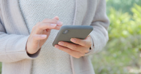 Close up of use of mobile phone at city park