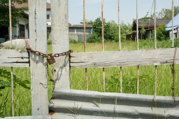 Closed meadow field gate with rusty chain