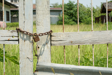 Closed meadow field gate with rusty chain
