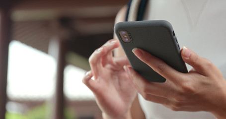 Close up of using mobile phone in Chinese garden