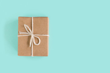 A handmade gift wrapped in kraft paper. On blue background.