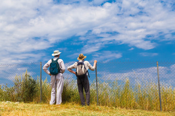 Fototapeta na wymiar tourists couple aged old looking the sky in spring