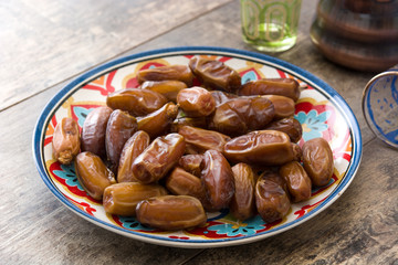 Dates food in plate and tea on wooden table