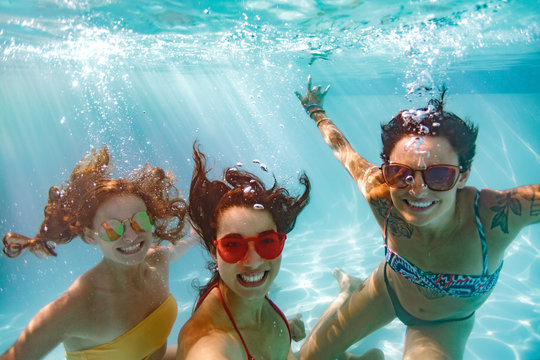 Underwater selfie of smiling females friends in pool