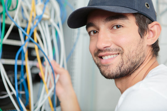 young adult electrician in front of fuse switch board