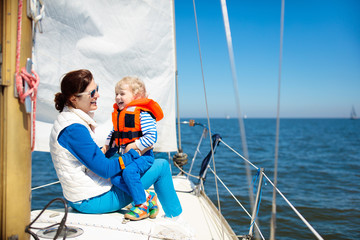 Family sailing. Mother and child on sea sail yacht.