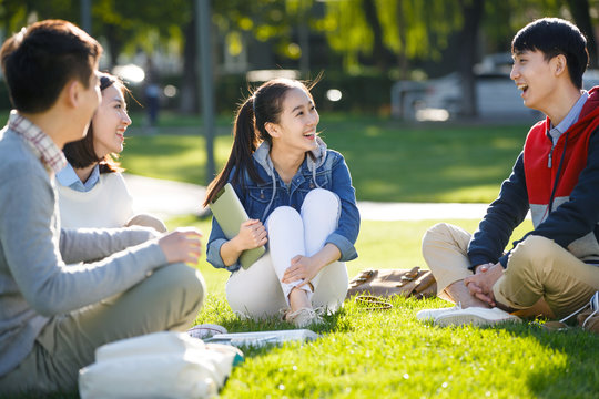 College students sitting on grass at college campus