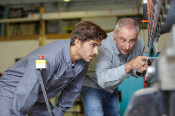 man with apprentice holding bearing
