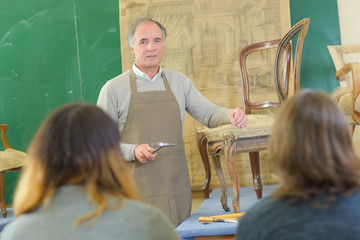 teacher showing students how to repair a chair