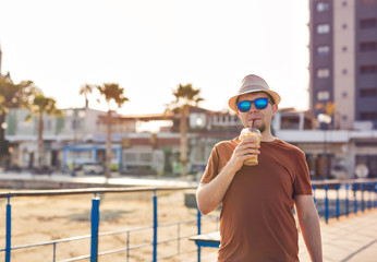 man with coffee frappe near sea feeling free enjoying freetime vacations