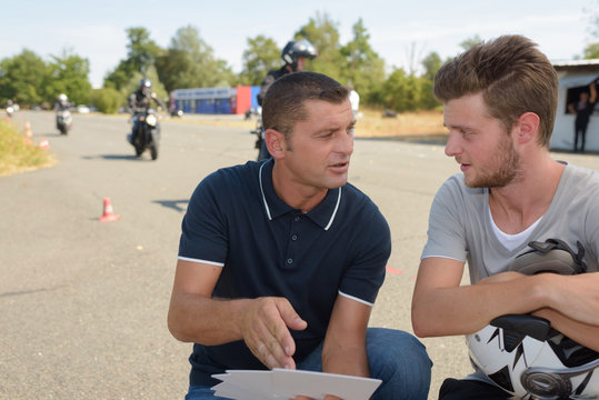 Motorcycle instructor talking to young man