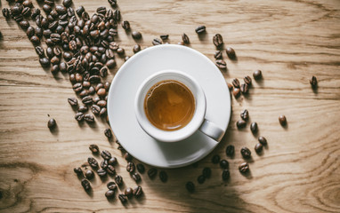 White Cup of Espresso on wooden table. Top view.