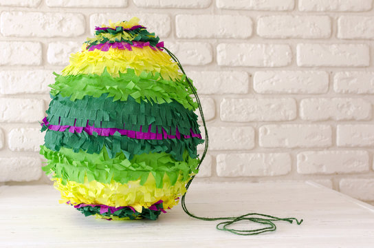 colored paper pinata on white wooden table