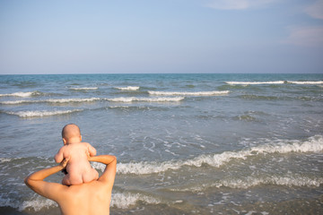 Fototapeta na wymiar Father and infant Son playing at the beach.